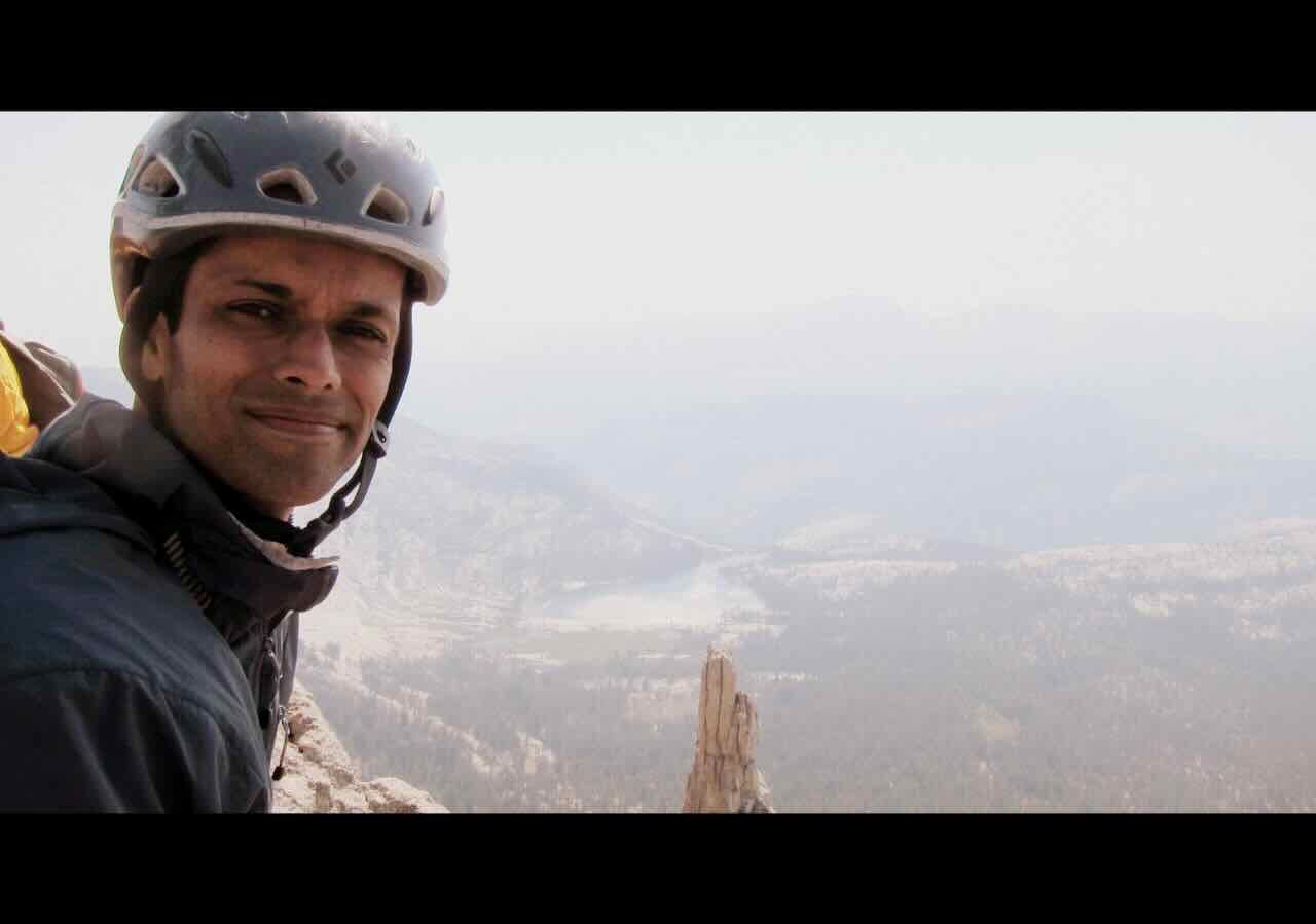 Anil on Cathedral Peak summit in climbing gear