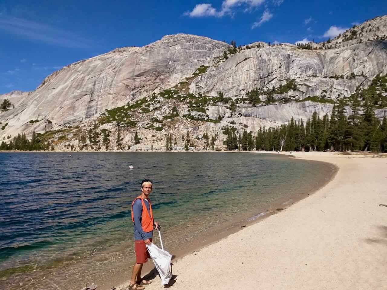 Anil volunteering during Yosemite Facelift by a lake and granite dome
